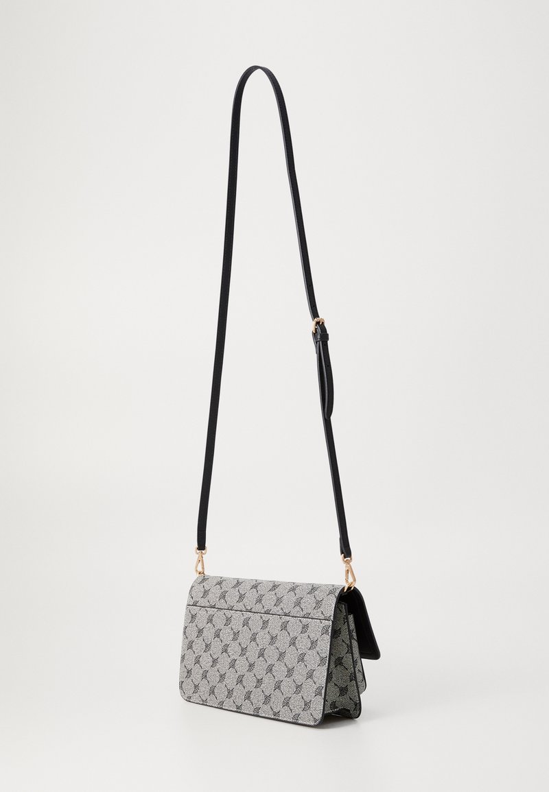 Borsa a spalla rettangolare con motivo ripetuto in bianco e nero, tracolla nera regolabile e accessori in tonalità oro su sfondo semplice.