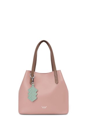 Rosa Lederhandtasche mit glatter Textur und zwei stabilen Griffen, versehen mit einem blattförmigen Anhänger. Kombiniert mit hellfarbenen, locker sitzenden Hosen.