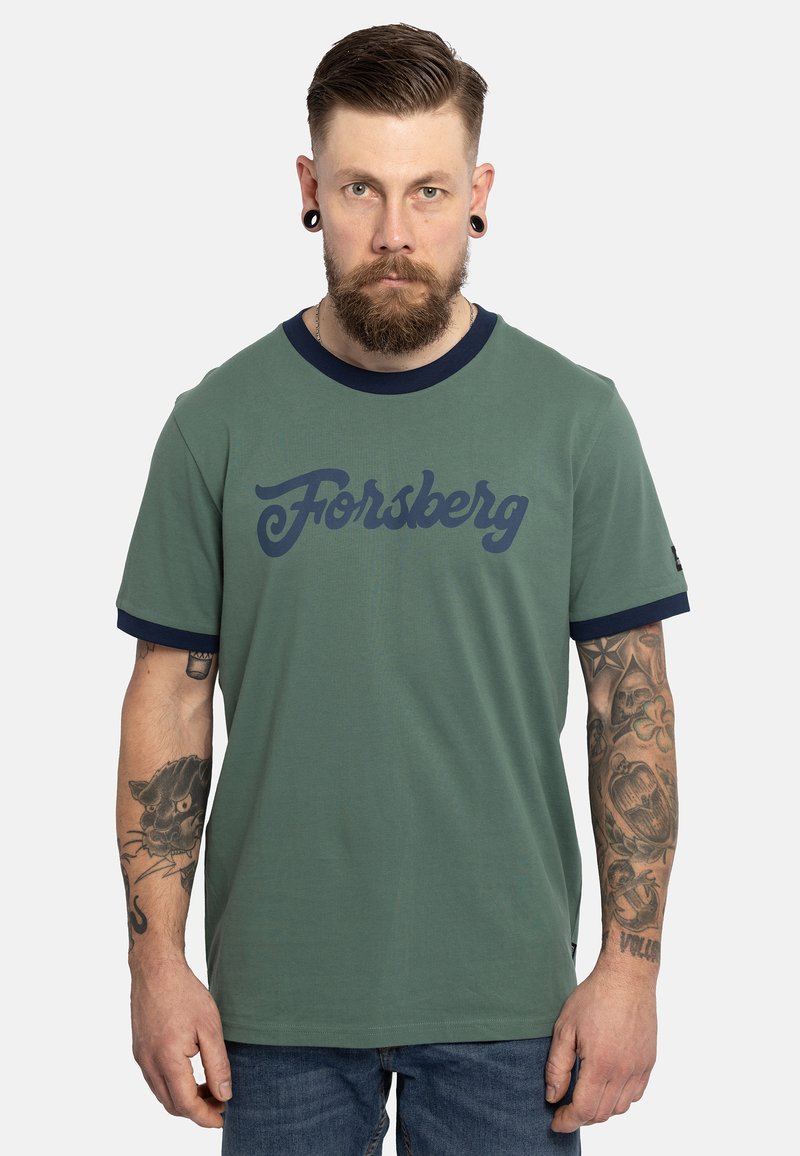 Camiseta verde con cuello redondo y mangas acanaladas en azul marino, que presenta un gran logo en azul marino de "Forsberg" en el pecho. Textura de tela suave.