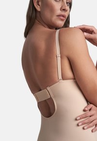 Body in tonal nude con spalline regolabili e chiusura a gancio sul retro. La texture liscia e il design aderente migliorano il supporto.