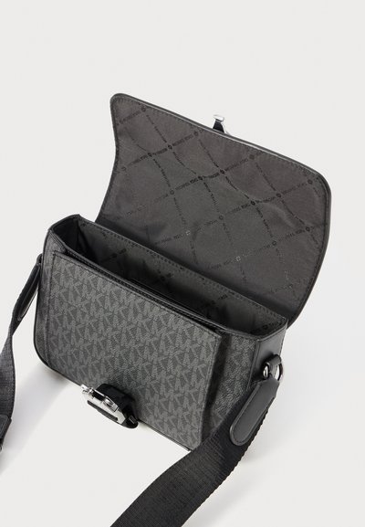 Sac bandoulière gris avec motif monogramme Michael Kors, extérieur texturé, fermeture à rabat magnétique, bandoulière réglable et grands compartiments intérieurs.