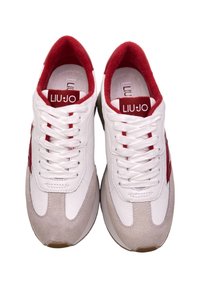 Sneaker bianchi e rossi con una combinazione di pelle liscia e suede. Presentano lacci bianchi, un colletto imbottito e dettagli testurizzati sui lati.