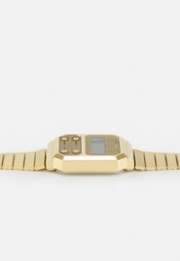 Reloj digital dorado con esfera cuadrada, presenta tres botones en dorado y acentos de color, además de una pulsera metálica articulada con eslabones rectangulares.