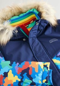 Marineblauer isolierter Mantel mit mehrfarbigem Camouflage-Muster, Kapuze aus Kunstfell und gefüttertem Innenraum mit Regenbogenstreifen. Mit Reißverschluss und Druckknopfverschluss.