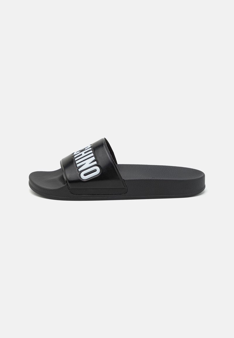 Black slide sandal with a glossy upper, featuring white text. Flat sole with a textured finish, suitable for casual wear.