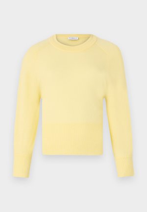Žltý pletený sveter s dlhými rukávmi, rebrovaným golierom a lemom. Mäkká textúra, mierne skrátený strih, s raglánovými rukávmi.