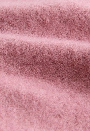 Roze vilt stof met een zachte, donzige textuur en golvende plooien, die de warme uitstraling en lichte aard benadrukken.