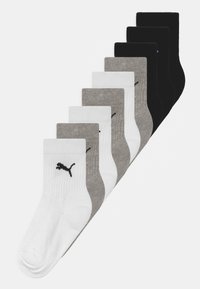 Set med ankelsockor i färgerna svart, grå och vit. Tillverkade av ett mjukt, texturerat tyg med en ribbad design och en liten svart logotyp.
