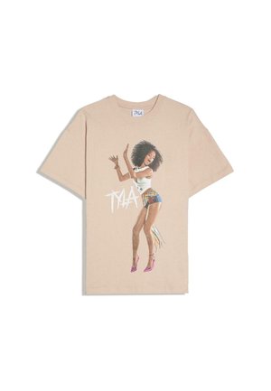 T-shirt beige avec un graphisme représentant une femme dansant, portant un short coloré, un haut blanc, des talons roses, avec le texte "TYLA" à côté d'elle.