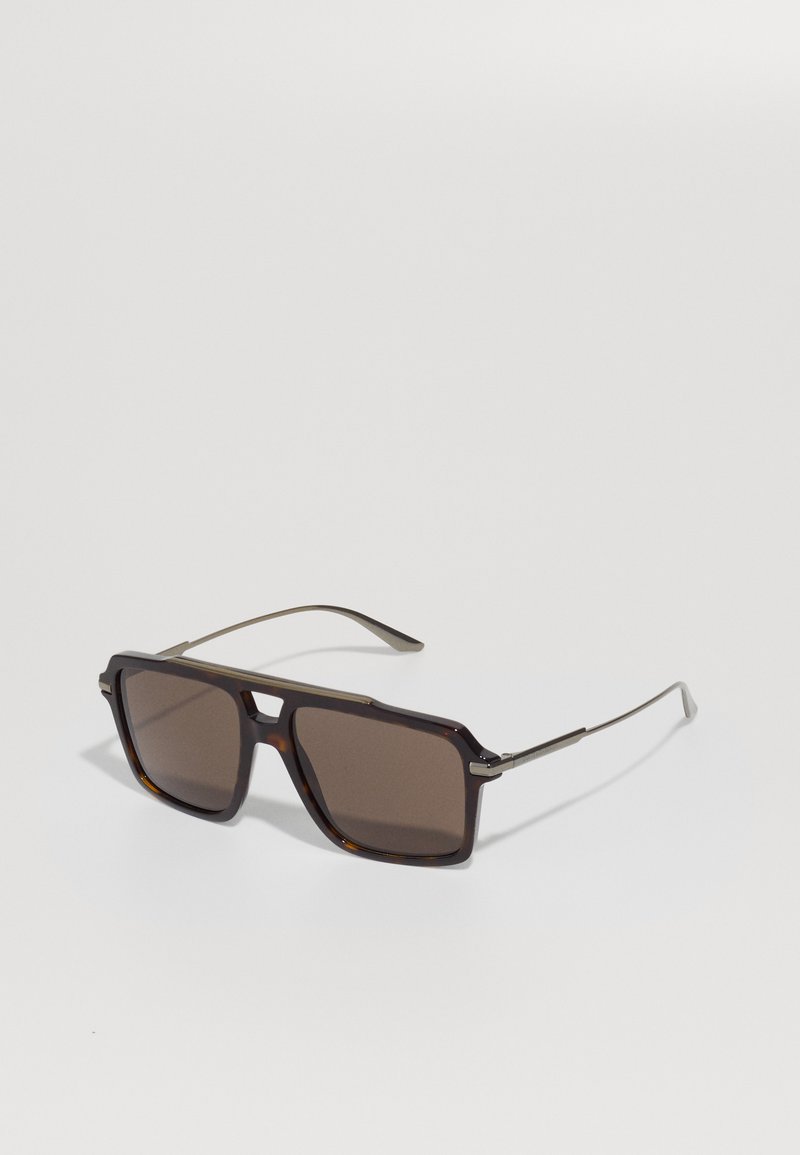 Ochelari de soare pătrați cu o ramă din plastic de tortoiseshell închis, cu lentile marron și brațe subțiri din metal cu un detaliu subtil de balama.