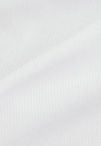 Texturerad vit tyg med ett subtilt mönster. Materialet är slätt med en lätt glans och fin diagonal ribbning över ytan.