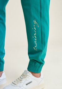 Freddy CON ELASTICO SUL E DETTAGLI FLOREALI - Pantalones deportivos - greenlake