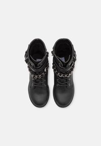 Černé kotníkové boty s matným koženým povrchem, zdobené dvojitými pásky a řetízky, kulatou špičkou a šněrováním v přední části.