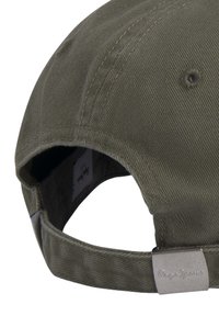 Gorra verde oscura con una tela suave y texturizada. Presenta un visor curvado, una correa ajustable y un detalle de logo metálico en la parte posterior.