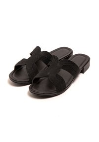 Chanclas negras con un diseño de punta abierta, que presentan correas texturizadas cruzadas y un tacón bajo. Suela sintética suave.
