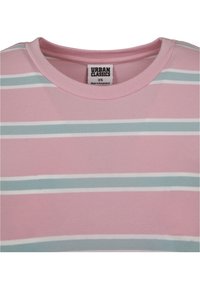 T-shirt rose à rayures avec des rayures horizontales bleu clair et blanches, présentant un col rond et une étiquette au niveau du col. Fabriqué en tissu doux.