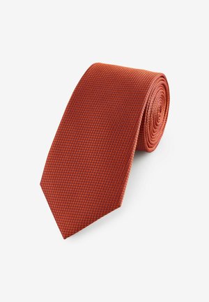 Textured red tie, crafted from woven fabric, featuring a subtle rectangular pattern. Tapered end with a rolled design for storage.