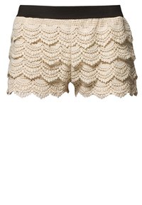Spetsshorts i off-white med en scalloped design och texturerade lager. Har en svart elastisk midja för komfort.