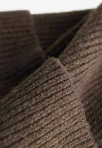 Material de culoare maro, cu o suprafață moale și texturată, având dungi verticale. Se pare că este gros și cald, ideal pentru îmbrăcăminte.