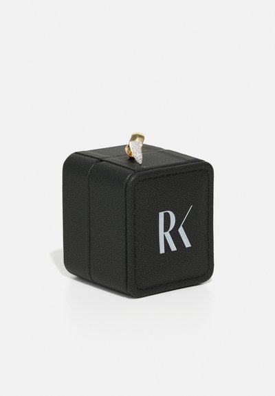 Cutie de bijuterii din piele neagră cu un accent lucios de argint și aur pe capac, având un logo "RK" în alb pe față.