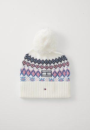 Hvit strikket lue med en fluffy pom-pom, med flerfargede geometriske mønstre og en ribbet hvit mansjett. Svarte og rosa detaljer er synlige.