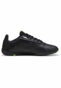 Baskets de sport noires avec une tige synthétique lisse, des panneaux latéraux texturés et des accents vert fluo sur le talon et la languette. Design bas.