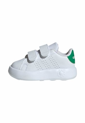 Hvid småbørns-sneaker med to velcrobånd, perforerede sidetaljer og en grøn hælflap med delvist logo på hvid baggrund.