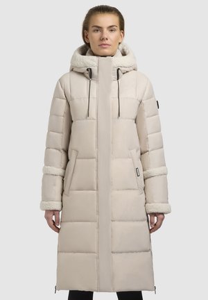 Lang, lys beige pufferjakke med en fluffet hætte, vandret quilte, sidelommer og teksturerede manchetter, med en lynlåslynlås foran.