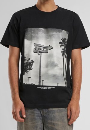 Schwarzes T-Shirt mit kurzen Ärmeln, das eine grau skalierte Grafik eines Kalifornien-Straßenschilds mit der Aufschrift "CALIFORNIA LOVE" und Palmen zeigt. Legere Passform.