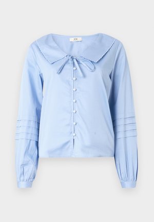Blusa azzurro chiaro a maniche lunghe con un ampio colletto smerlato, chiusura con bottoni sul davanti e maniche arricciate con dettagli a pieghe.