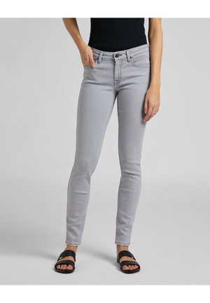 Jeans ajustados grises con cierre de botón, bolsillos frontales y una textura suave. Estilizados con sandalias negras de slides.