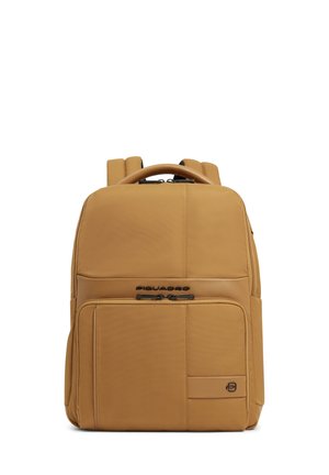 Rechthoekige rugzak in tan kleur met voorvak met rits, bovenhandvat, gewatteerde schouderbanden en Piquadro-logo op het voorpaneel.