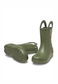 Bottes de pluie vertes en caoutchouc avec une finition texturée, des trous circulaires de chaque côté, et une semelle à motif pour une meilleure traction.