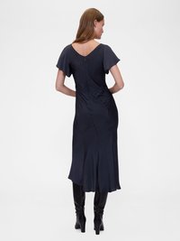 Rochie midi din satin în nuanța albastru închis, cu mâneci scurte tip flutură, decolteu în V la spate și tiv evazat. Asortată cu cizme negre până la genunchi.