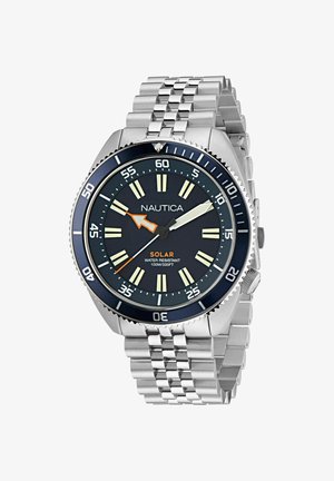 Reloj solar Nautica con un dial redondo azul marino, marcadores de hora luminosos, banda de acero inoxidable y un bisel giratorio, resistente al agua hasta 100m.