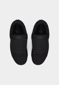 Ζευγάρι μαύρα αθλητικά παπούτσια Etnies με κορδόνια, σε θέα από πάνω πάνω σε λευκό φόντο.