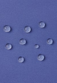 Wassertropfen auf einer strukturierten blauen Stoffoberfläche, die ein feines Gewebe-Muster mit glatten, reflektierenden Flächen zeigt.