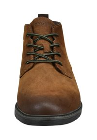 Braune Wildleder-Ankelboots mit grünen Schnürsenkeln, runder Zehenpartie, strukturiertem Obermaterial und schwarzer Gummisohle, mit einem minimalistischen Logo auf der Zunge.