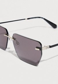 Ochelari de soare dreptunghiulari negri cu lentile gri, accente metalice argintii și brațe subțiri drepte, evidențiind un design minimalist.