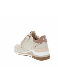 Scarpa sportiva beige con tomaia testurizzata, pannello perforato, collarino imbottito e accenti marrone chiaro. Presenta una suola intermedia bianca e una suola in gomma.