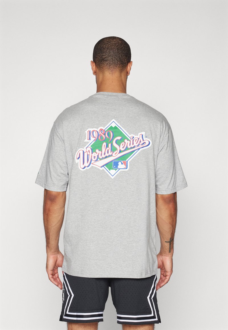 Camiseta de algodón gris con un gráfico colorido de la Serie Mundial de 1989 en la parte posterior, con un ajuste relajado y mangas cortas.