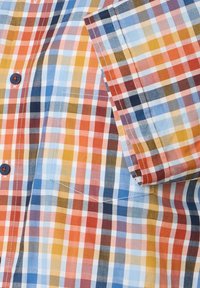 Kariertes Hemd mit multicolorierten Quadraten in Rot, Blau, Gelb und Weiß. Mit kurzen Ärmeln und blauen Knöpfen.