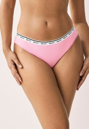 Roze katoenen stringondergoed met een contrasterende zwart-wit "NEXT" merkband. Soepele textuur en een laag uitgesneden ontwerp.