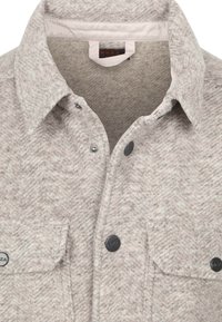 Grijs gestreept overhemd met een kraag, voorzien van zwarte metalen knopen en opgestikte zakken. Gemaakt van gestructureerde, geweven stof.