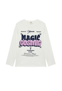 Biała koszula z długim rękawem z odważnym, wielokolorowym tekstem graficznym. Projekt zawiera frazy takie jak "MAGIC COSMIC" oraz gwiazdy, w luźnym kroju.