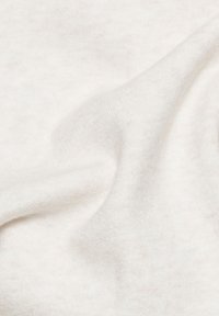 White textured fabric with a soft, fuzzy surface, showing subtle variations in shades and a gentle drape.