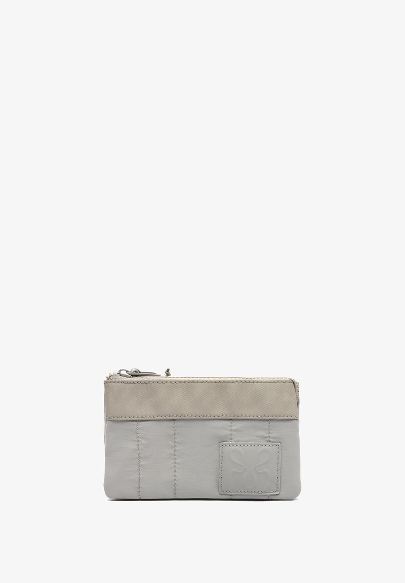 Pequeño bolso rectangular con cremallera, panel superior beige, sección inferior acolchada en gris claro y parche con logotipo cuadrado cosido en el frente.