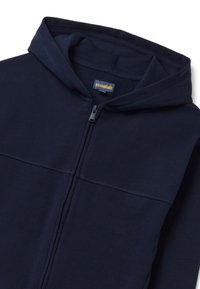 Felpa con zip di colore blu navy in tessuto morbido, dotata di cappuccio con cordino, zip frontale e un piccolo etichetta con logo all'interno del colletto.