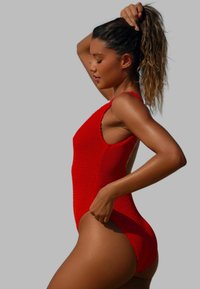 Maillot de bain une pièce en tricot rouge avec de larges bretelles, dos décolleté et tissu texturé, conçu pour une silhouette ajustée.
