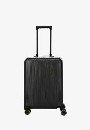 Valigia rigida nera con scanalature verticali, quattro ruote doppie girevoli e manico telescopico esteso.